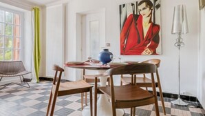A dining area with a checkered floor, a round table, and four wooden chairs. - Villa Giroflé by Interhome (Arcachon)