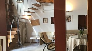 A modern interior with a staircase, a dining area, and a seating area.