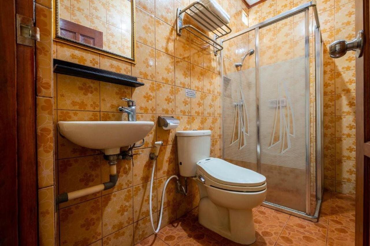 A bathroom with a toilet, sink, and shower.