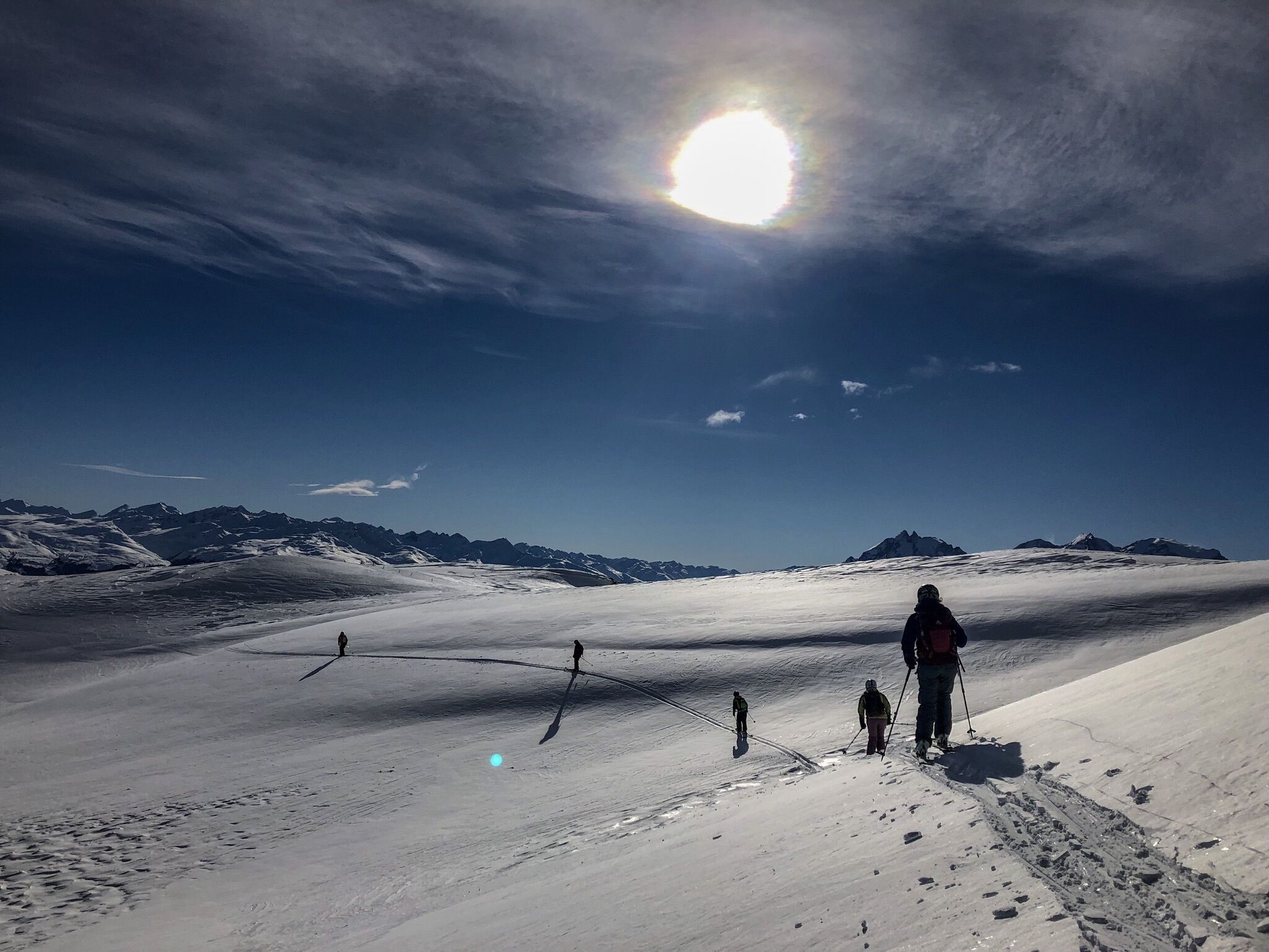 A snowy landscape with a clear sky and distant mountains.