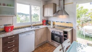 A compact kitchen with a dishwasher, oven, and a red coffee maker. - Nice house with private pool and barbacue (Vidreres)