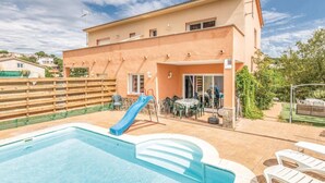 A swimming pool with a blue slide, outdoor seating, and a building with a flat roof. - Nice house with private pool and barbacue (Vidreres)