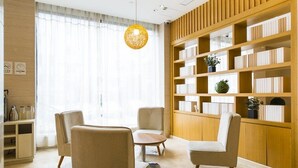 A modern library with bookshelves, a round table, and comfortable seating. - JI Hotel Shanghai Chuansha Branch (Shanghai)