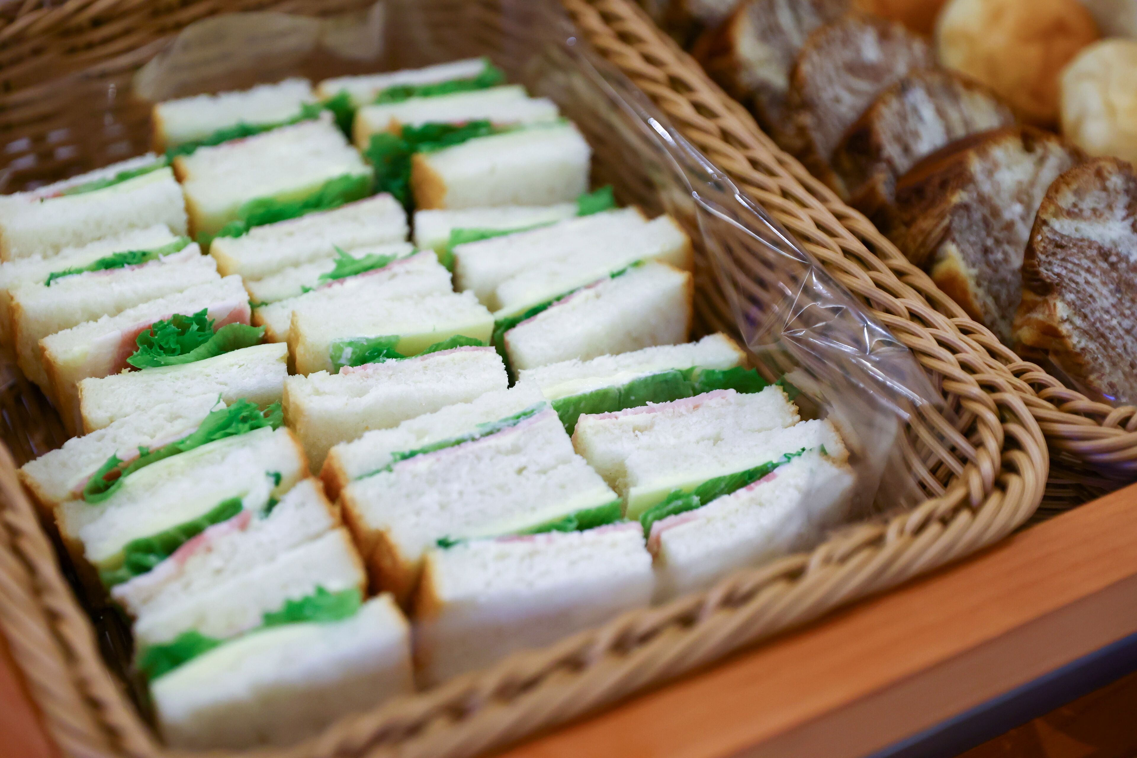 A basket of sandwiches and bread slices.