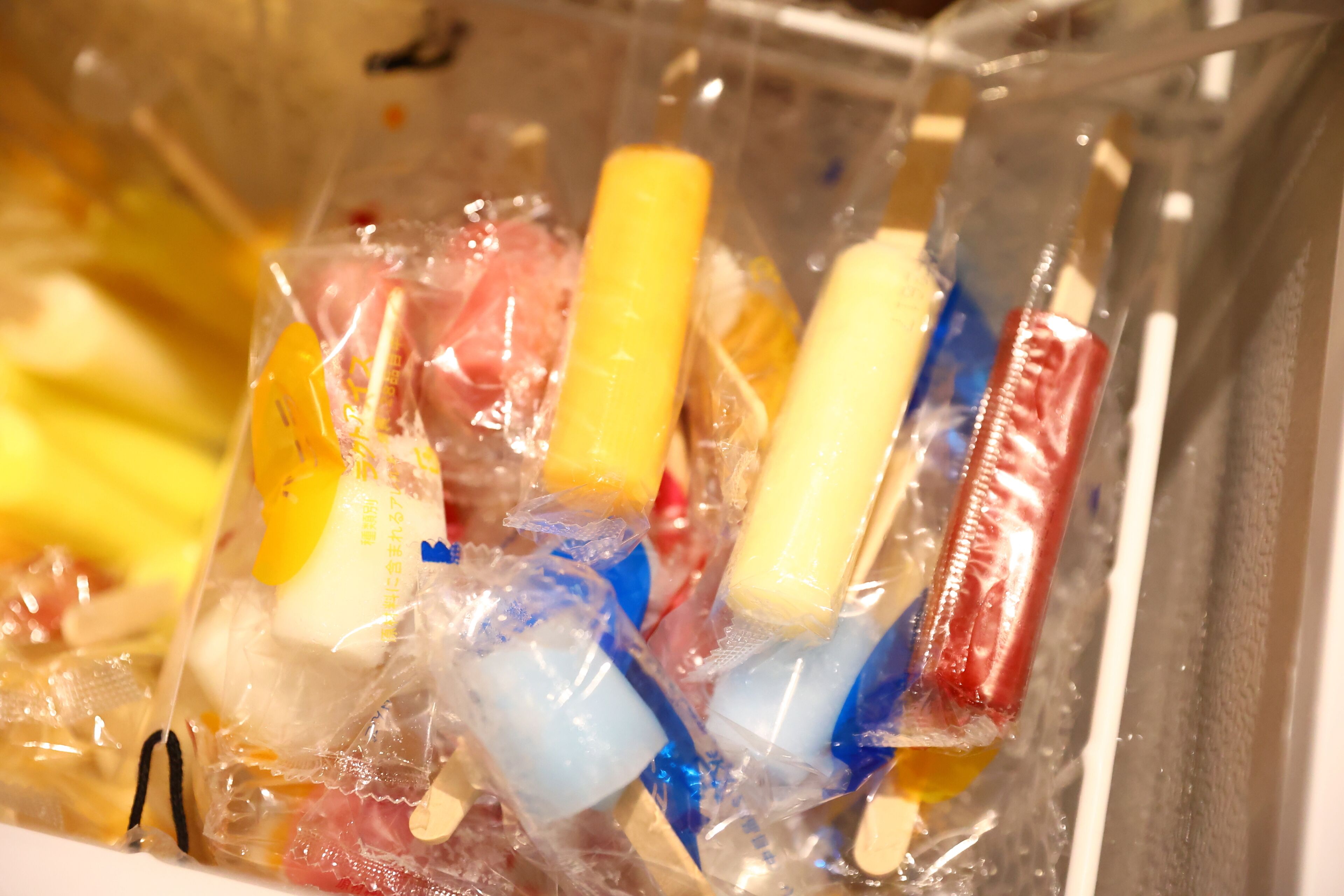 A container with various frozen treats in clear plastic bags.