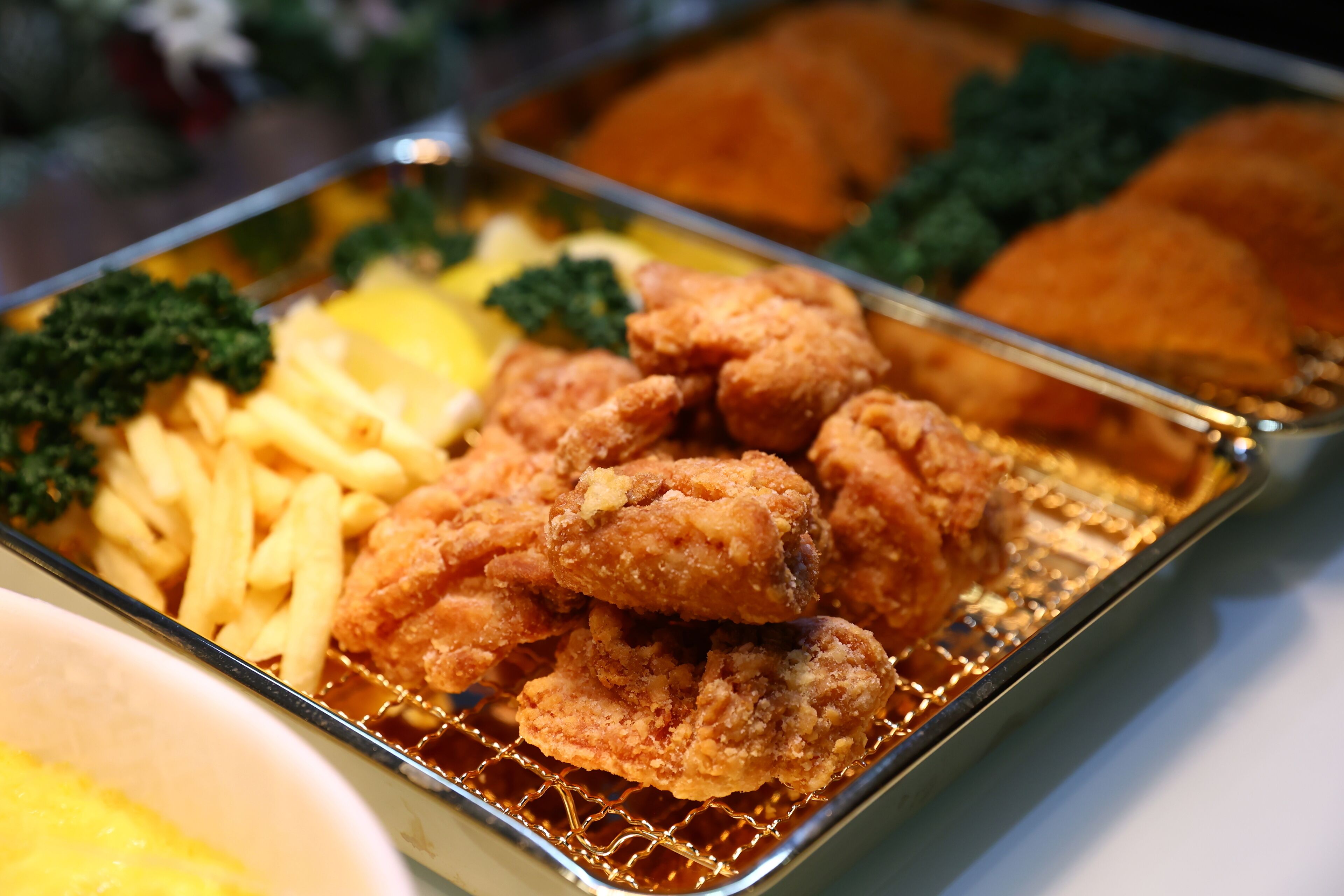 Una bandeja con pollo frito, papas fritas y brócoli.