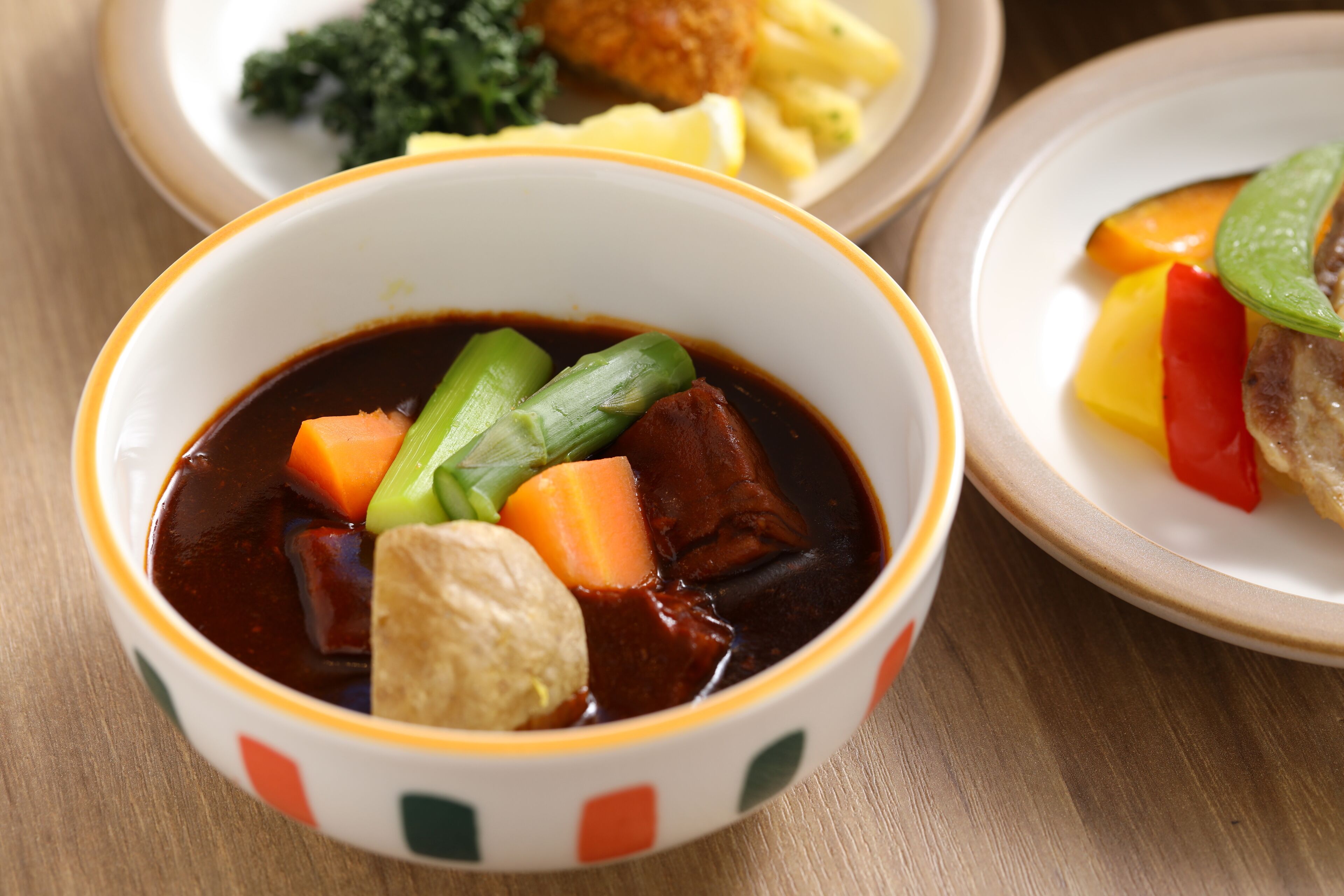 A bowl of stew with vegetables and tofu.