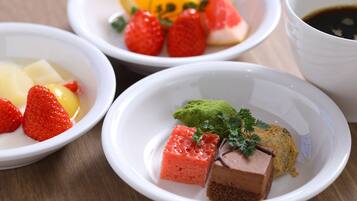 Cuatro tazones blancos con diferentes alimentos, como fresas, pasta verde y chocolate.