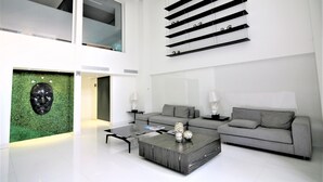 Una sala de estar moderna con un sofá gris, una mesa de centro y una pared de acento verde.