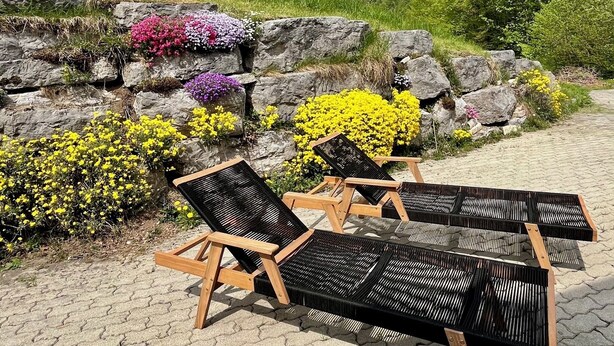 Outdoor lounge chairs, a stone wall, and a mountainous backdrop. - Vacation apartment Untersberg up to 2 pers., 34 m², with terrace (Bischofswiesen)