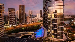 Un hotel moderno con piscina e vista sullo skyline della città.