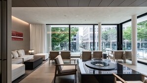 A modern hotel lobby with a seating area, a fire feature, and large windows offering city views. - The Royal Park Hotel Iconic Kyoto (Kyoto)