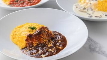 A plate of food with a yellow base and a dark sauce, and another plate with a similar dish but with a white base and a creamy sauce.