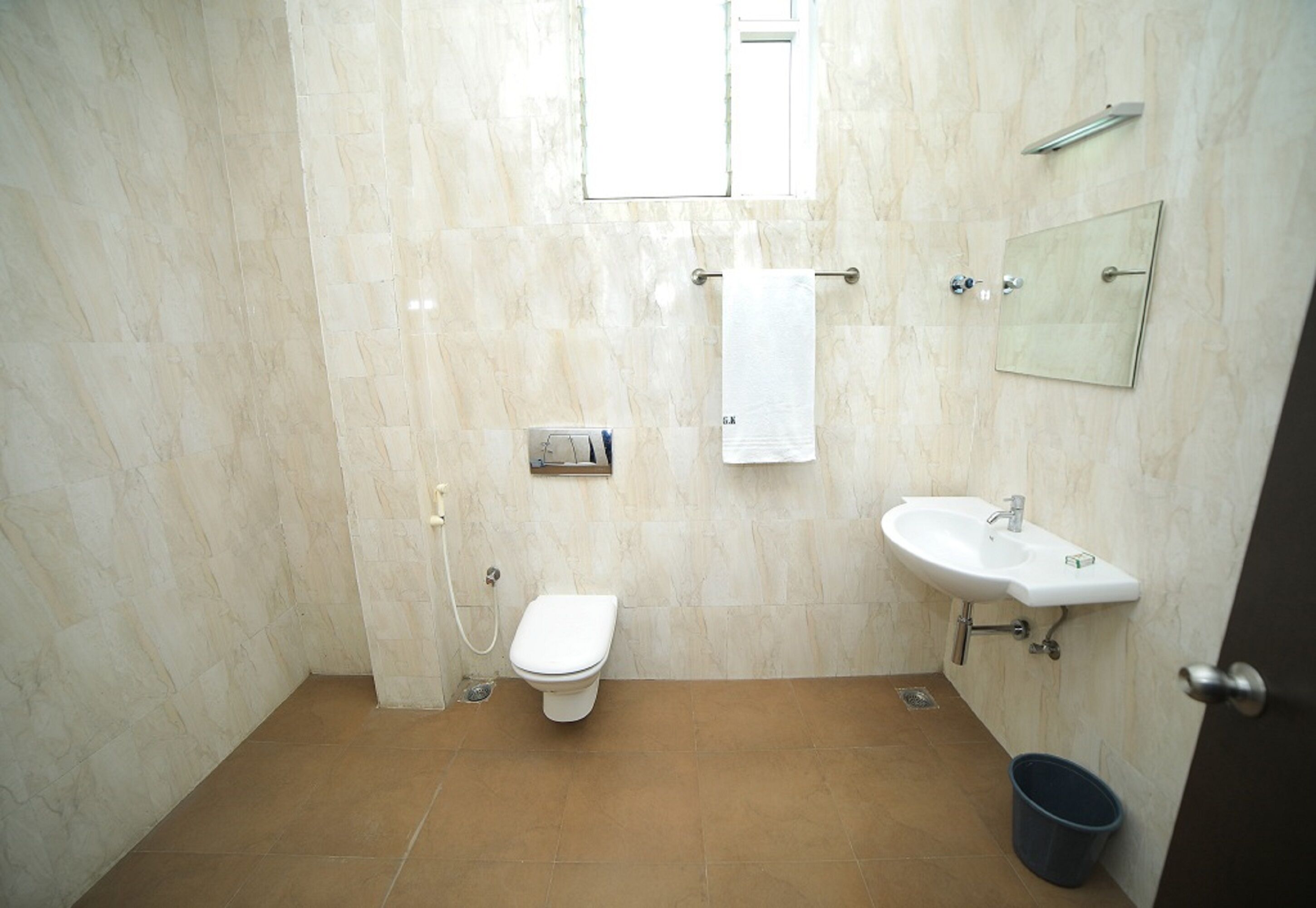 A bathroom with a toilet, sink, and towel rack.