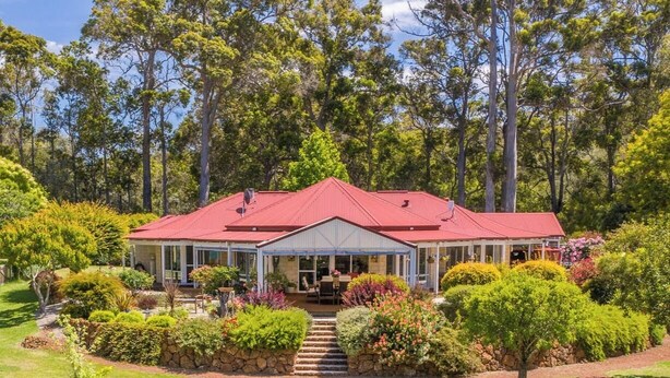 A house with a red roof, surrounded by lush greenery and trees. - Twin Gums: Large family home, beautiful gardens on banks of Denmark River (Denmark)