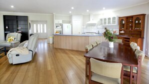 A spacious living room with a sofa and a dining table. - Twin Gums: Large family home, beautiful gardens on banks of Denmark River (Denmark)