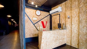 Ein Empfangsbereich mit einer Holzwand, einer Uhr und einem V-förmigen Design.