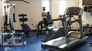 Un gimnasio con cintas de correr, máquinas de pesas y un banco.