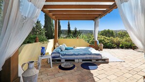 Una cama bajo una pérgola con vistas al paisaje.