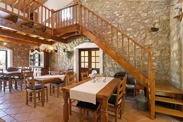 Ein Essbereich mit Holzkubaturen, einer Steinsäule und einer Holztreppe.