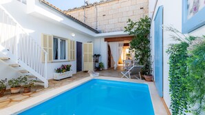 A swimming pool with a white staircase, potted plants, and a chair. - Vacation Home "Casa Cantino" with Pool, Wi-Fi & Terrace (Santa Margalida)