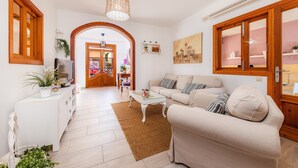 A living room with a sofa, coffee table, and a TV on a white cabinet. - Vacation Home "Casa Cantino" with Pool, Wi-Fi & Terrace (Santa Margalida)