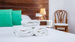 A neatly made bed with white linens, a wooden headboard, a green pillow, a wooden chair, and a bedside lamp. - Pet-Friendly Vacation Home Moli Den Barret with Mountain View, Pool & Wi-Fi (Santa Margalida)