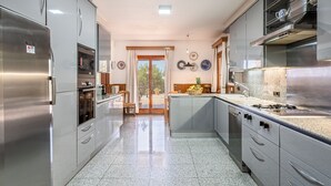 Una cocina moderna con electrodomésticos de acero inoxidable, una isla central y vistas al exterior.