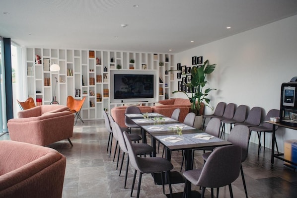 A modern conference room with a long table, multiple chairs, a television, and a bookshelf. - A House In Estoril (Cascais)