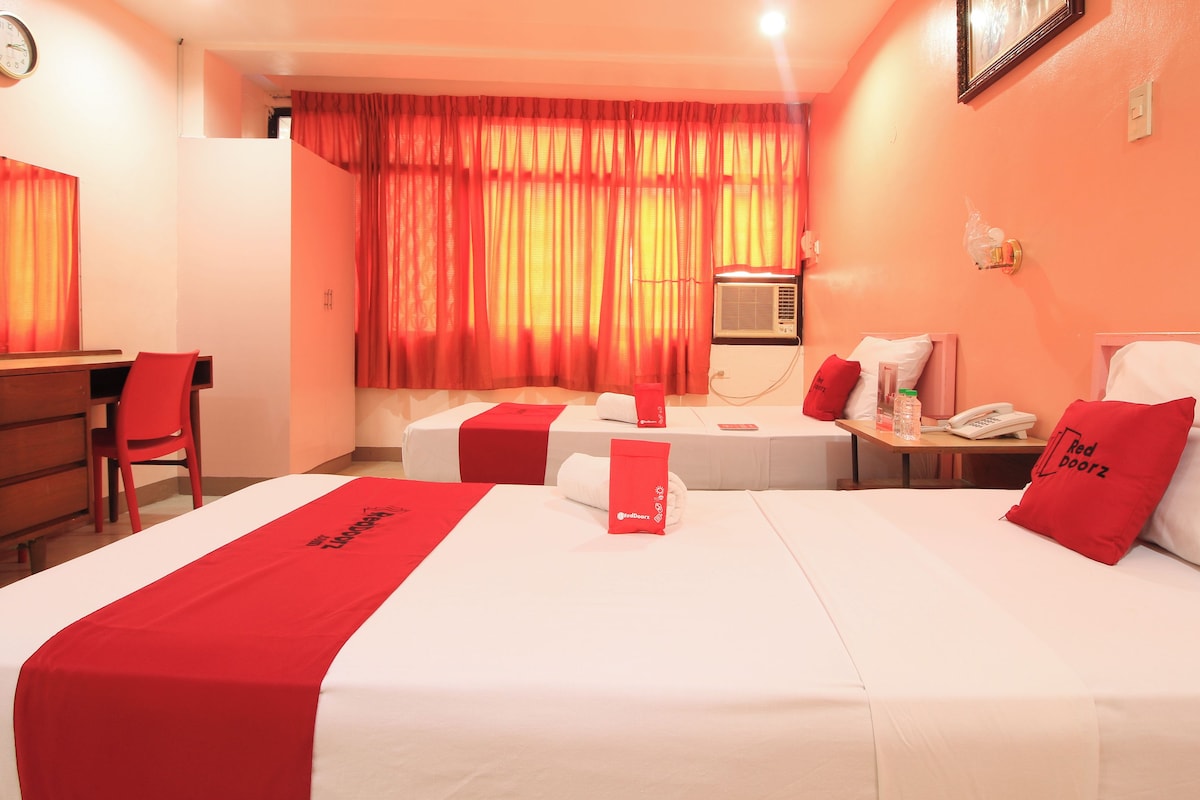 A hotel room with two beds, a desk, and a chair.