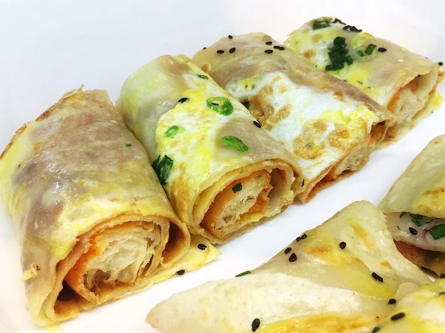 Un plato de rollitos primavera con relleno y decoración visibles.
