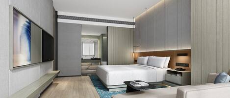 Una habitación de hotel moderna con una cama grande, mesitas de noche, un televisor de pantalla plana y una zona de estar.