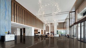 A spacious lobby with a high ceiling, modern furnishings, and a reception desk. - Yancheng Marriott Hotel (Yancheng)
