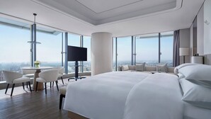 A modern hotel room with a large bed, a round table, and a TV. - Yancheng Marriott Hotel (Yancheng)