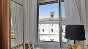 A hotel room with a large window, a mirror, a lamp, and a radiator. - Campo de Fiori, Navona - Fashion Domus (Roma)