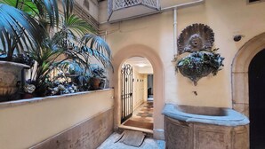 A narrow courtyard with a tiled floor, a stone bench, and potted plants. - Campo de Fiori, Navona - Fashion Domus (Roma)