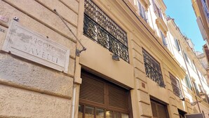 A building facade with a sign reading "Vicolo RM Savele!" and decorative wrought iron window grilles. - Campo de Fiori, Navona - Fashion Domus (Roma)