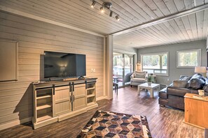 Relax in this stylish living area with a large flat-screen TV, comfortable sofa, and beautiful views of the outdoors.