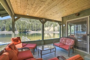 Relax in a serene lakeside setting with an outdoor seating area offering a peaceful view of the surrounding forest.