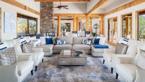A spacious living room with a sectional sofa, a coffee table, and a stone fireplace.
