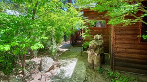 A wooden cabin with a stone pathway leading to a wooden deck.