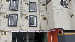 Un edificio de varios pisos con numerosas ventanas, un mural en la fachada y un cartel que dice 'SV Dream Stay'.