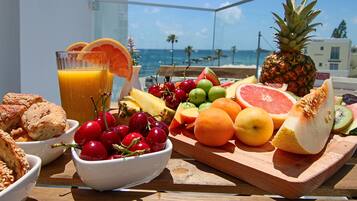 Enjoy a leisurely breakfast on the balcony with a view of the ocean and surrounding buildings.