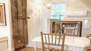 Un comedor con una mesa y sillas de madera, una lámpara de araña y una rústica puerta de madera.