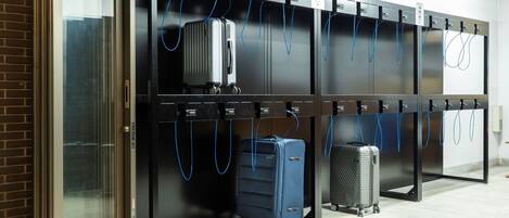 Un espace de stockage de bagages doté de plusieurs casiers et d’une entrée avec une porte en verre.