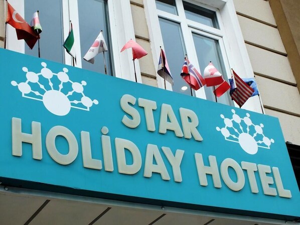 A sign for the Star Holiday Hotel with flags of various countries displayed outside. - A Warmly Welcome Home to Star Holiday Hotel 34 (Istanbul)