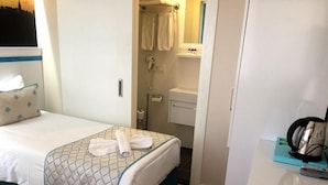 A hotel room with a bed, a bathroom, and a desk with a telephone and headphones. - A Warmly Welcome Home to Star Holiday Hotel 34 (Istanbul)