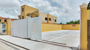 Un parking clos, avec un bâtiment jaune en arrière-plan.