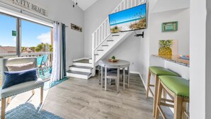 Ein modernes Interieur mit einer Treppe, einem Essbereich und Blick auf den Strand.