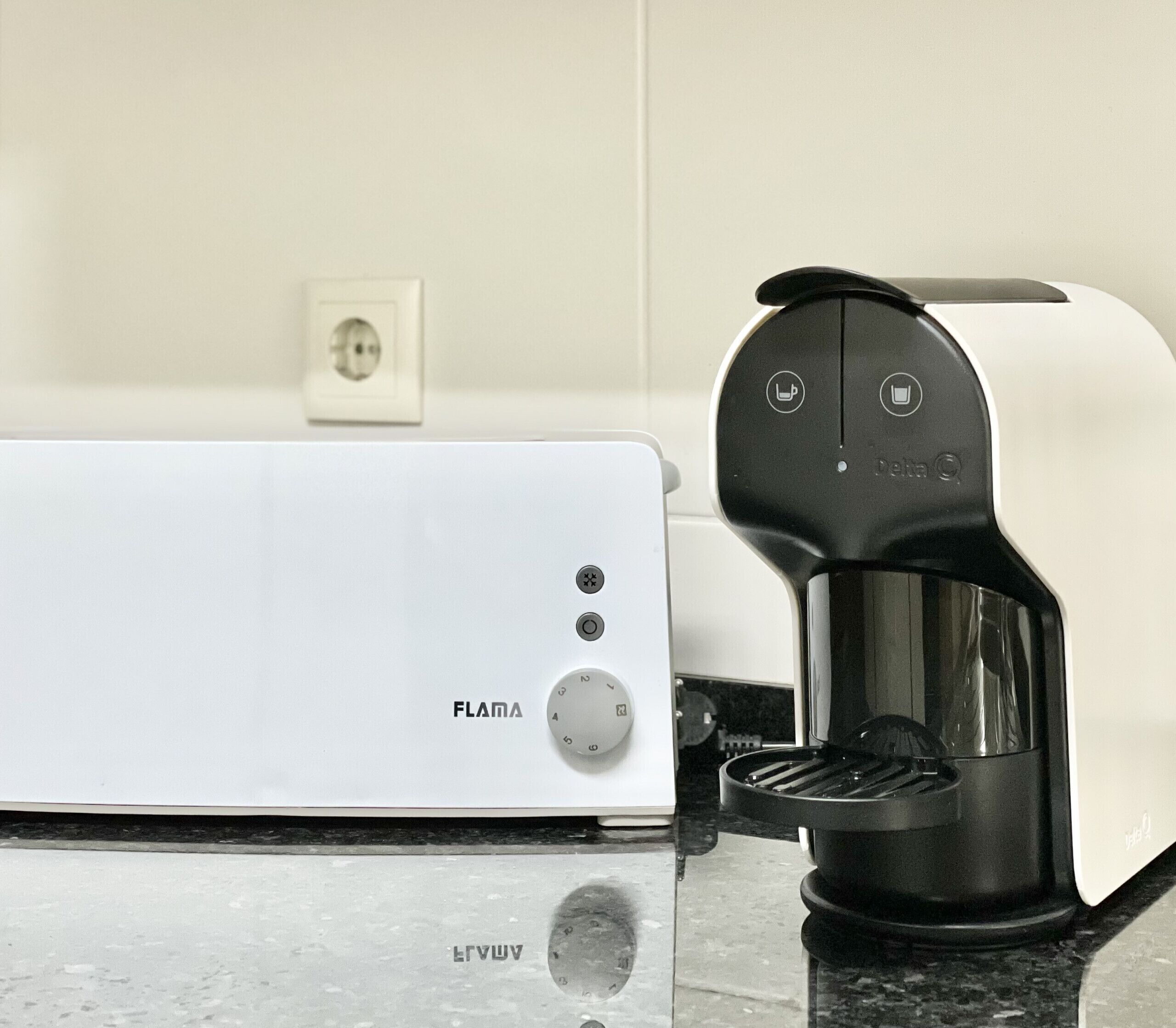 A white FLANA toaster with a black coffee maker on a kitchen counter.